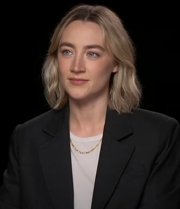 Head-and-shoulders portrait of Saoirse Ronan seated against a dark background, looking slightly off camera.