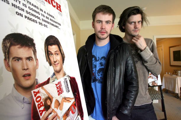 Zach Cregger and Trevor Moore, identified by press materials as stars of the upcoming film "Miss March," pose with promotional posters and magazines at a publicity event.